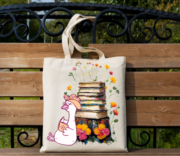 Book Lover Tote Bag with silly goose reading a book with stack of books and flowers