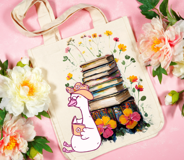 Book Lover Tote Bag with silly goose reading a book with stack of books and flowers