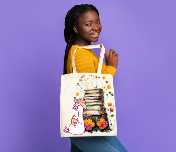 Book Lover Tote Bag with silly goose reading a book with stack of books and flowers