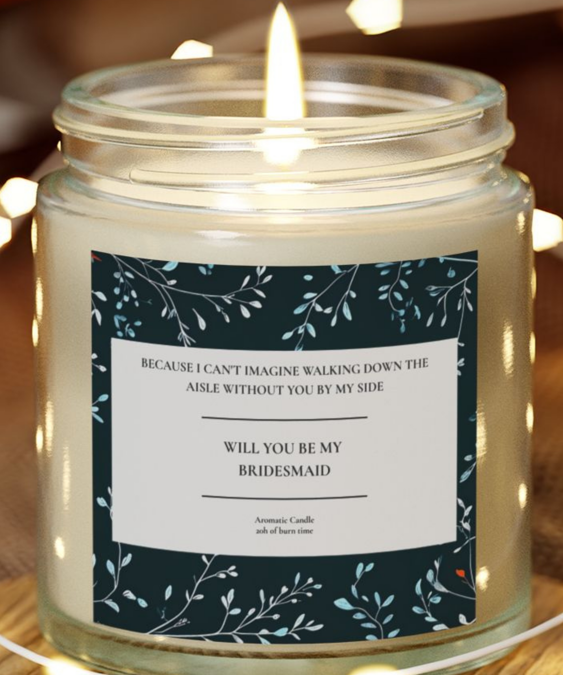 Candle in a jar with a label asking 'Will you be my bridesmaid?' on a wooden surface.