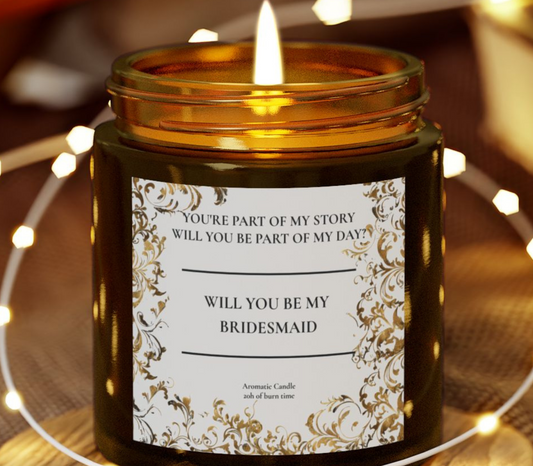 Candle in a jar with a 'Will You Be My Bridesmaid?' label on a blurred background with lights.